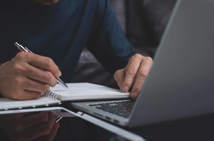 Someone is practicing writing next to a laptop