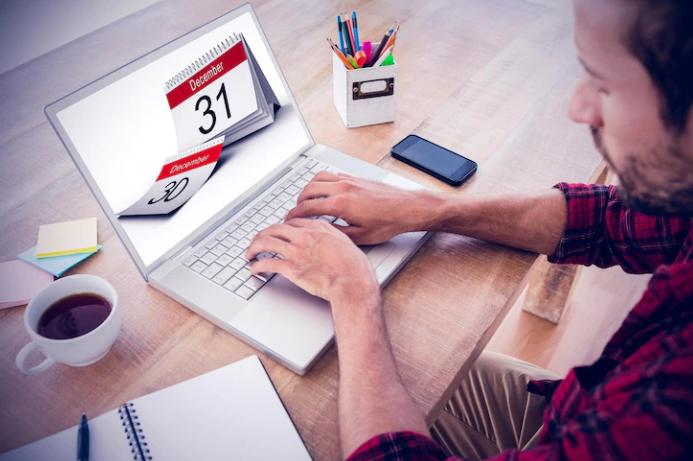 The man who is working with the laptop and the page shows different dates