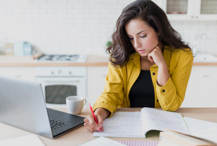 A girl in a yellow shirt is writing