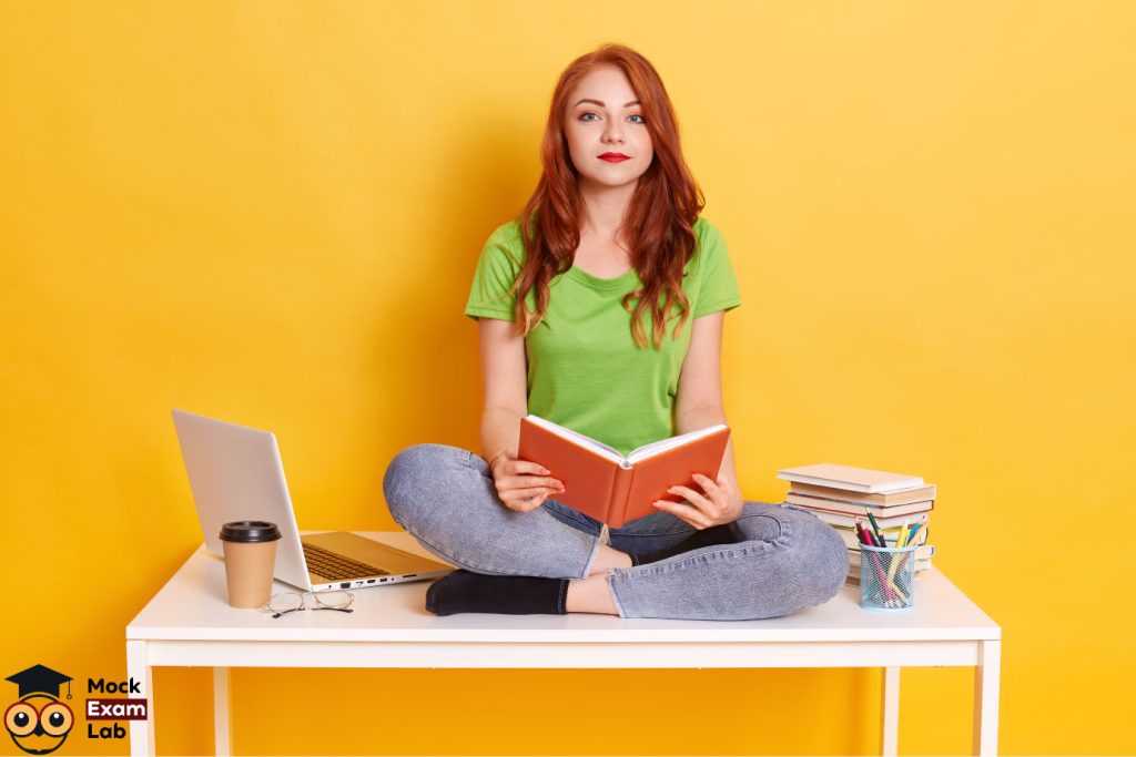 A smiling young woman with red hair is holding a book